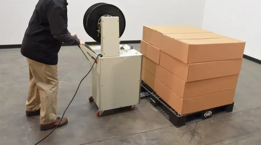 person using a gray strapping machine